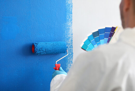 artisan tient rouleau palette couleurs peint mur blanc bleu services peinture murale concept peinture