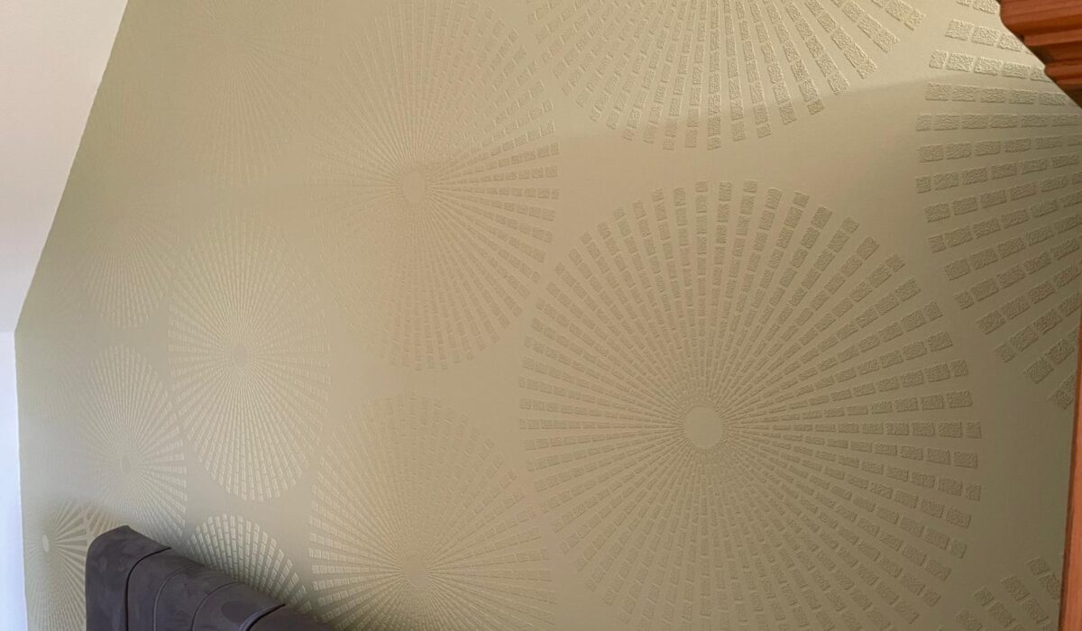 Une chambre avec un lit et un mur avec un motif